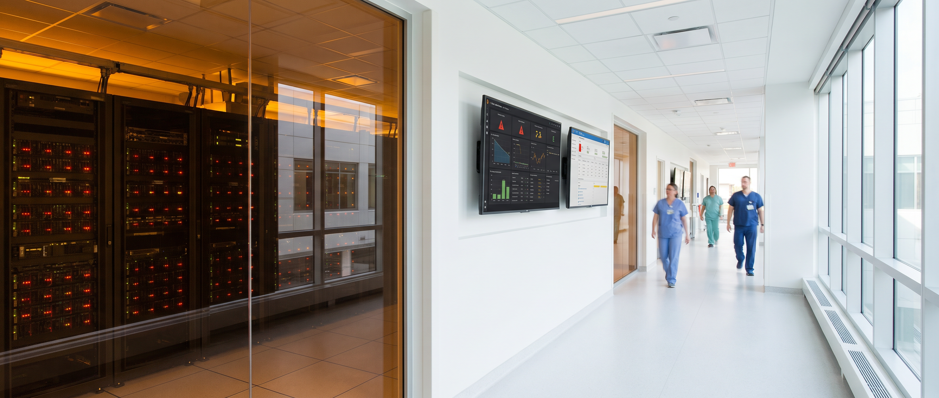 Hospital corridor with server room visible through glass — red warning lights on server racks alongside bright clinical hallway with healthcare workers and monitoring dashboards